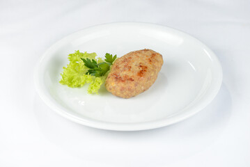 cutlet with herbs on a white plate