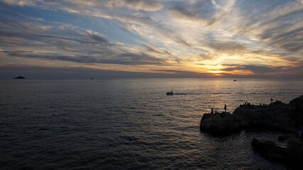 Serene Adriatic Sunset with Silhouetted Figures