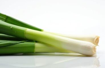 Fresh green and white spring onions arranged on a white surface with space for text