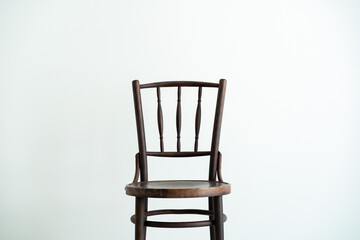 Vintage wooden chair isolated against a white wall