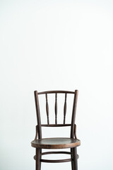 Vintage wooden chair isolated against a white wall