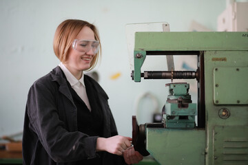 Young woman engineer working at machine tool