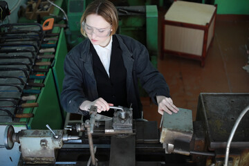 Young woman engineer working at machine tool