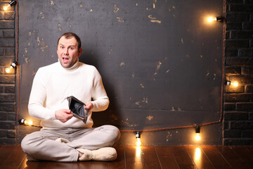 A man in a white sweater listens to music