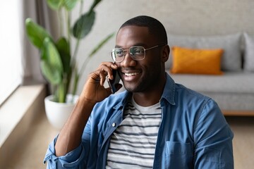 Happy african american man using mobile phone at home office for business call talk