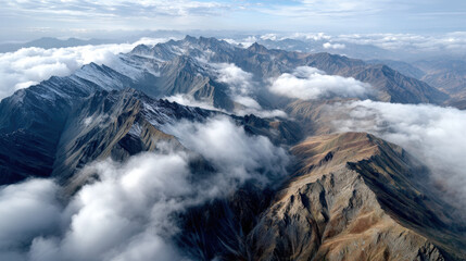 Fototapeta premium Majestic mountain range with snow capped peaks and clouds creating dramatic landscape