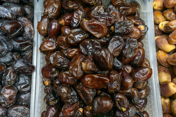 Date fruit on market stall fresh natural tropical healthy snack. Close up of ripe brown dates displayed on rustic market stall symbolizing abundance and natural harvest.