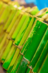 Traditional Thai Khao Lam with sticky rice roasted in bamboo segments. Crispy charred edges contrast soft interior, highlighting craftsmanship and rich culinary heritage.