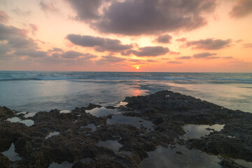 Sunset over the ocean with rocks