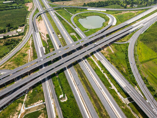 Drone shot a large highway interchange crossing over green farmlands in Thailand