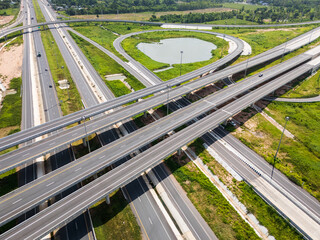 Drone shot a large highway interchange crossing over green farmlands in Thailand
