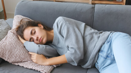Young woman experiencing chronic fatigue while resting on a cozy couch in soft lighting