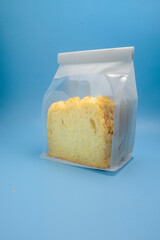 A sliced loaf of soft yellow bread is packaged in a clear, resealable plastic bag and placed...