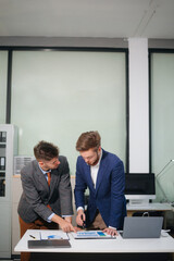 Caucasian business team collaborates on a new startup project, planning strategies with a tablet and laptop
