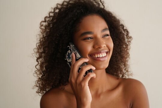 Portrait of a beautiful african american woman smiling while talking on her smartphone