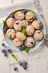 Cookies with blueberry filling sprinkled with powdered sugar closeup in the bowl on the table. Vertical top view from above