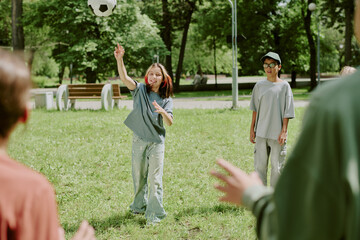 Diverse group of children with soccer ball in park, smiling and interacting outdoors, multiethnic...