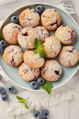Delicious Blueberry Cookies with mint and vanilla flavor sprinkled with powdered sugar close-up in a plate on the table. vertical top view from above