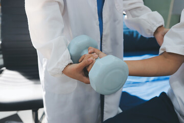 Unrecognizable uses blue hand weight during physical therapy session