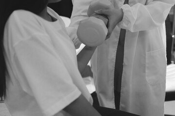 Unrecognizable uses blue hand weight during physical therapy session