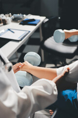 Fototapeta premium Unrecognizable uses blue hand weight during physical therapy session