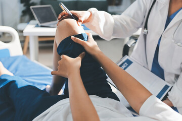 Female doctor hands doing physical therapy By extending the leg and knee of a male patient