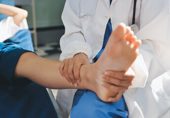 Female doctor hands doing physical therapy By extending the leg and knee of a male patient