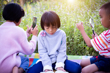 Kids exploring in forest with a magnifying glass