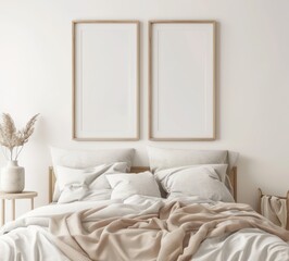 Two empty frames on a white wall above a bed with white bedding. a beige throw. and a vase with dried flowers
