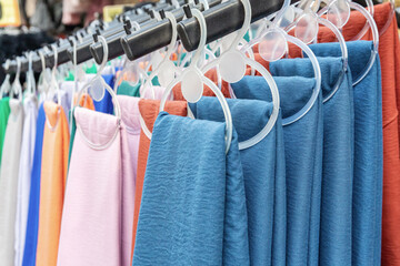 Colorful fabric textiles hanging on display in street market shop in Turkey