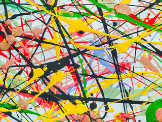 Abstract background made of acrylic and latex paint. Green, red, yellow and black spots of flowing splattered paint. Abstract Expressionism.