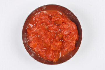 Close-up, top-down studio shot features a metal bowl filled with rich, chunky crushed tomatoes,...