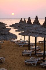 Sunset on the beach with beach umbrellas and sun loungers. Red Sea, Egypt. The perfect Resort beach in Sharm El Sheikh