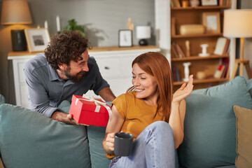A joyful moment unfolds as one family member presents a beautifully wrapped gift to another in a...