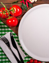 Round plate decorated with tomatoes, mushrooms, spinach, basil and spices. Dish on a white square...