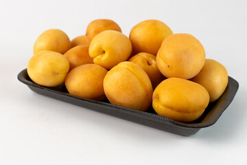 a tray with apricots close-up on a white background