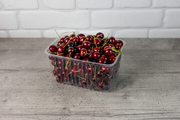 cherries in a transparent container on the kitchen table
