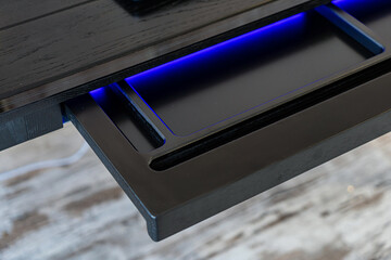 Top view of empty open wooden drawer office table with blue lightning. Modern office table with...