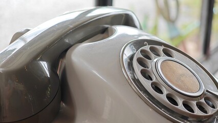 Old grey phone with dial plate, vintage telephone.