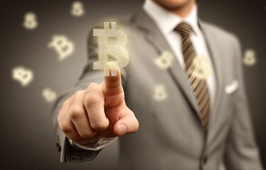 Businessman's finger pointing at a digital Bitcoin symbol