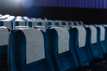 Blue chairs in an empty movie theater, low light