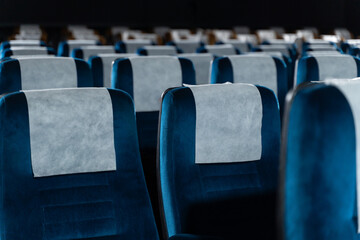Blue chairs in an empty movie theater, low light