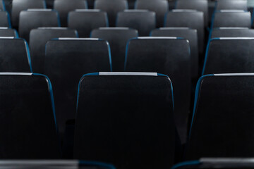 Blue chairs in an empty movie theater, low light
