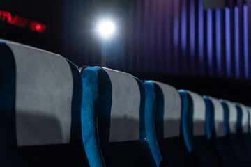 Blue chairs in an empty movie theater, low light