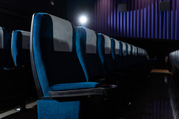 Blue chairs in an empty movie theater, low light