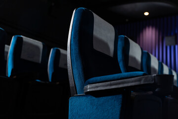 Blue chairs in an empty movie theater, low light