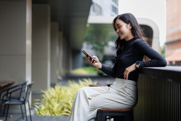 Young businesswoman using smartphone while relaxing outdoors