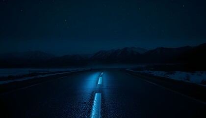 A lonely road stretches into the distance at night, illuminated by headlights.