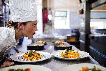Ribbon pasta dishes sitting on stainless steel countertop near window in busy kitchen