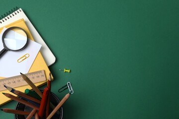 Flat lay with school stationery on green background, top view